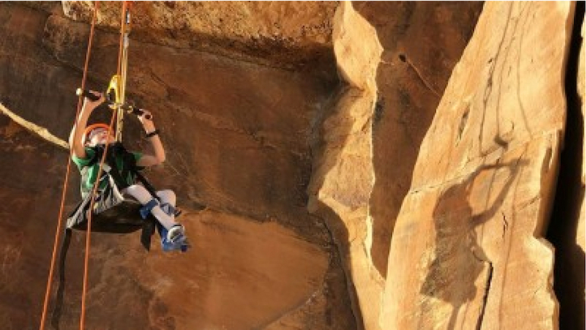 Young Kid climbing mountain in assisted seat