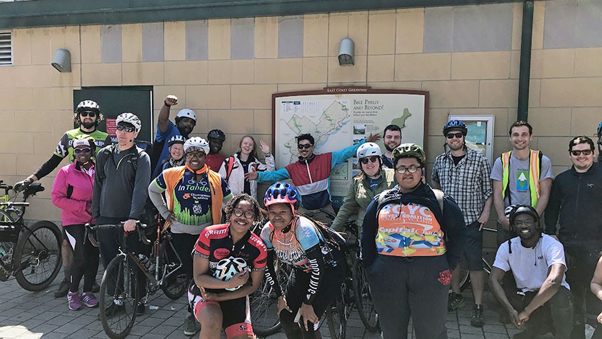A group of happy cyclists prepare to head out on a ride exploring the East Coast Greenway.