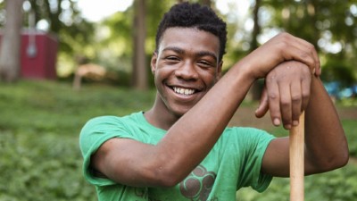 A young man in a green shirt smiles