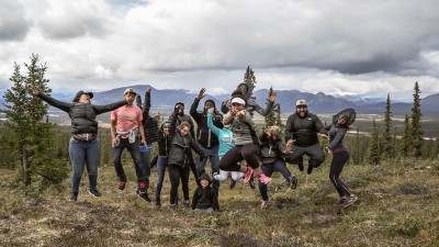 Jumping for joy and clicking their heels, a goups of friends celebrate exploring the outdoors.