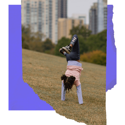 A youngster practices their handstand in a city park.